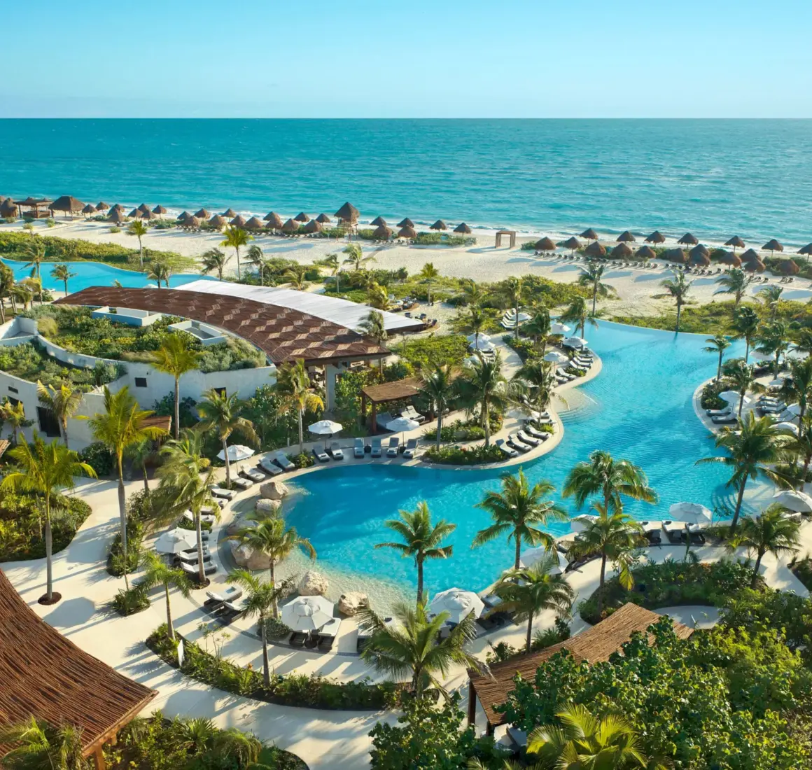 Bird’s-eye view of the Preferred Club pool area with cabanas and views of the Caribbean Sea.