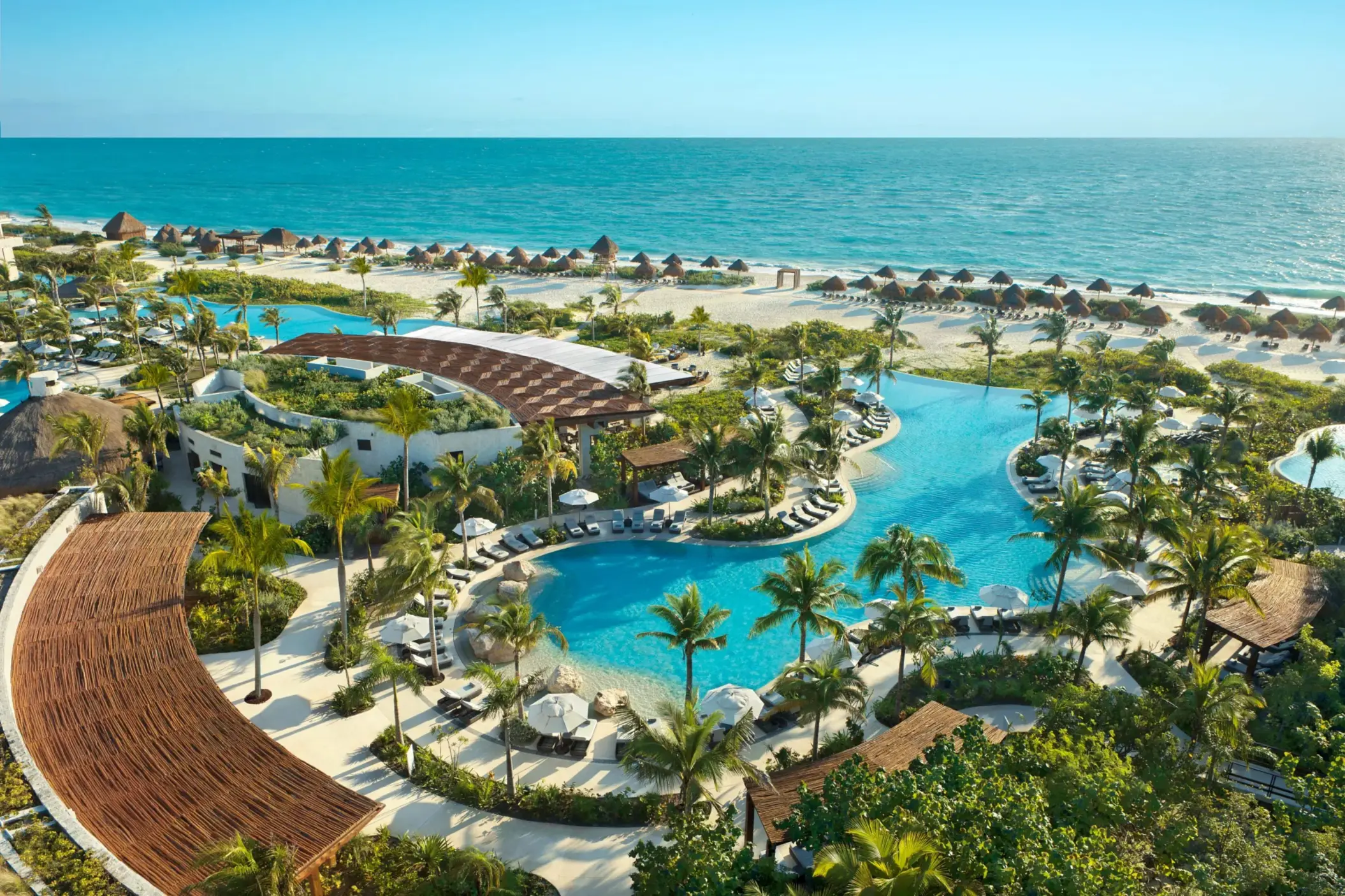 Bird’s-eye view of the Preferred Club pool area with cabanas and views of the Caribbean Sea.