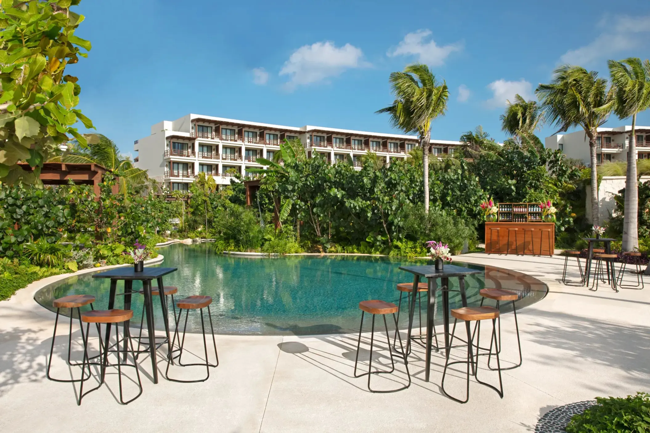 Outdoor cocktail setup next to a serene jungle pool, perfect for private events or receptions.