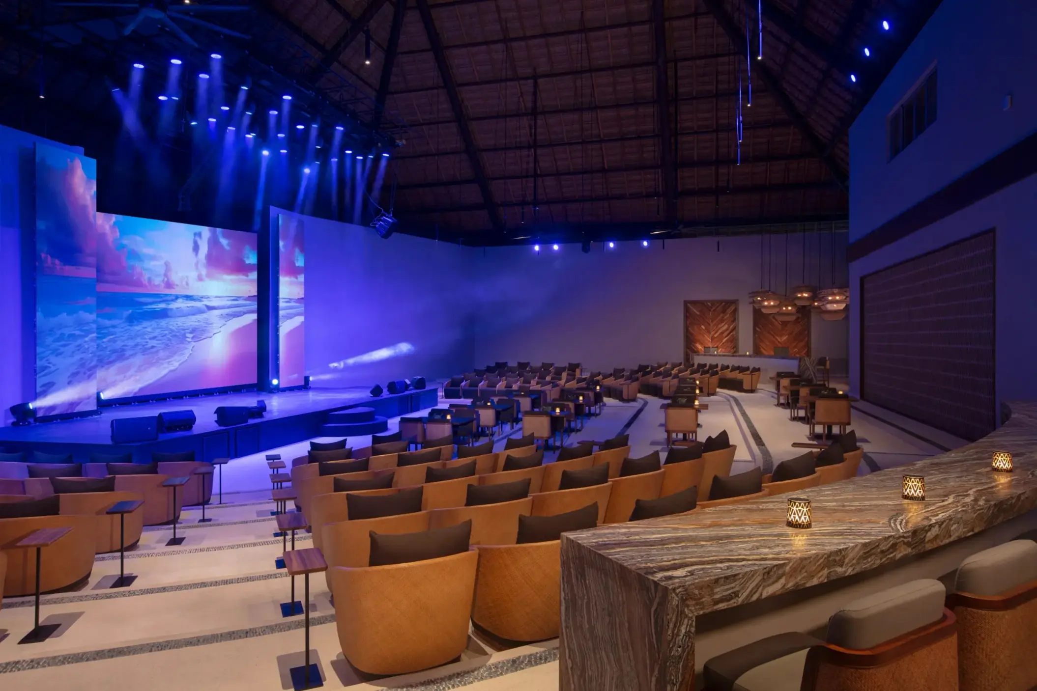Modern indoor theater with stage lighting and comfortable seating.
