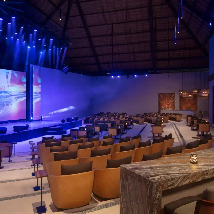 Modern indoor theater with stage lighting and comfortable seating.
