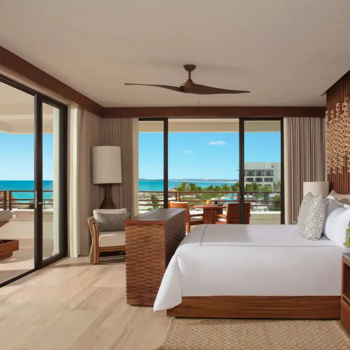 Spacious corner master suite bedroom with premium ocean views and elegant coastal decor.