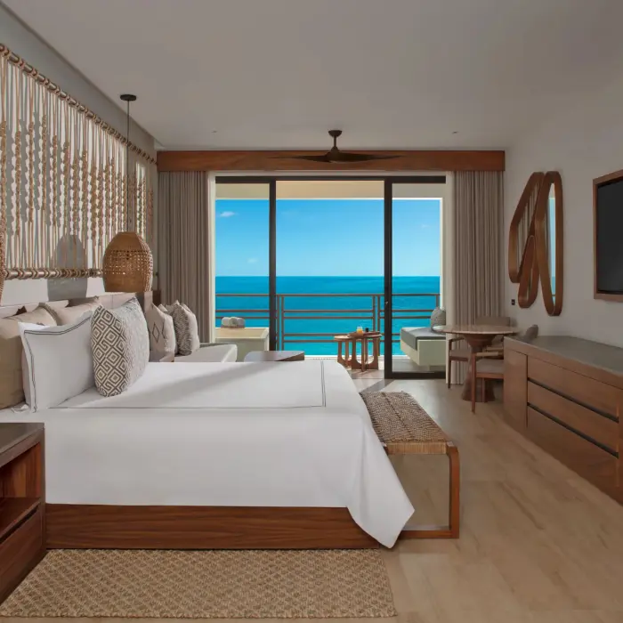 Junior suite with direct oceanfront views, stylish decor, and comfortable seating.