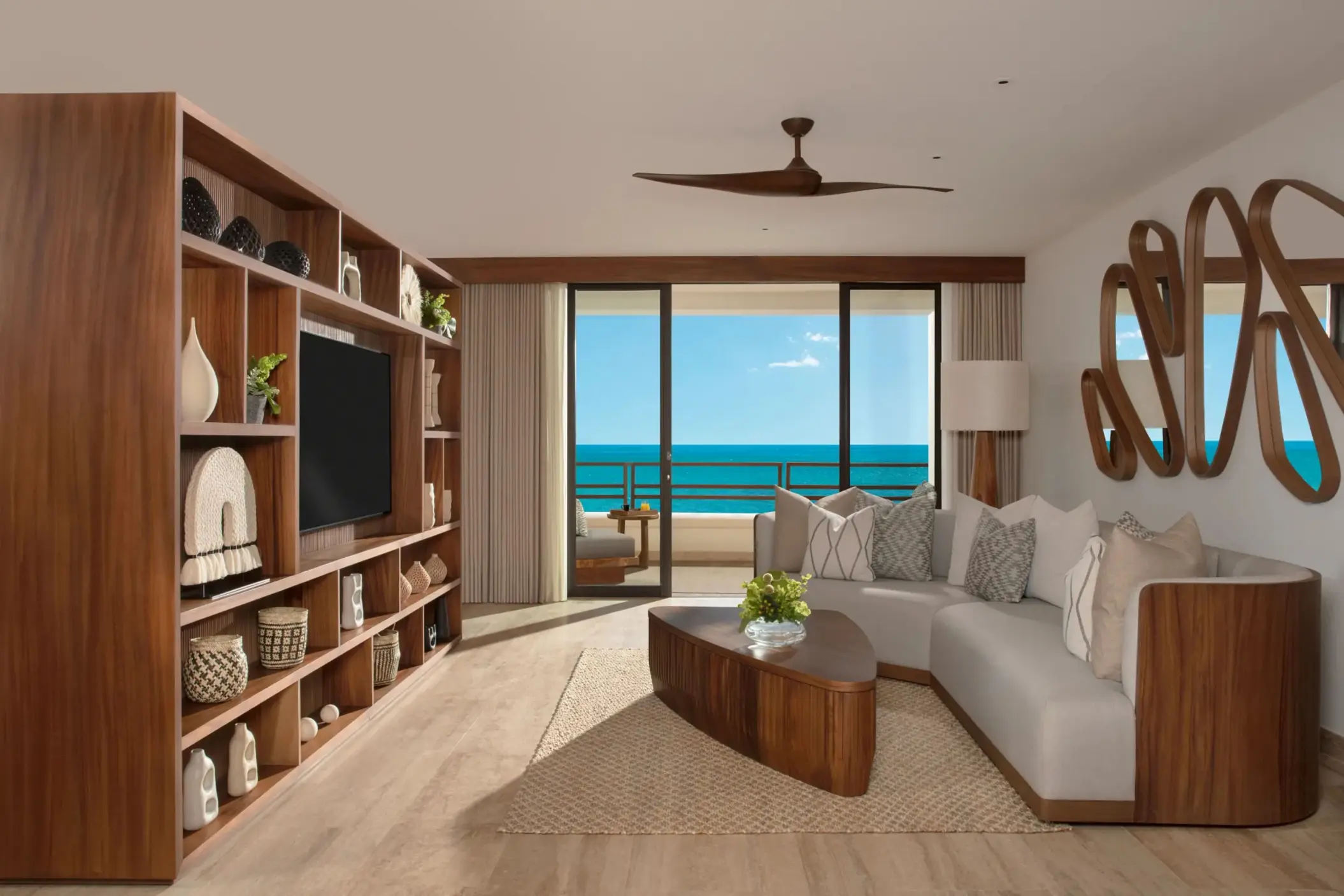Master Suite living room with ocean view, modern couch, wood decor, and entertainment center.