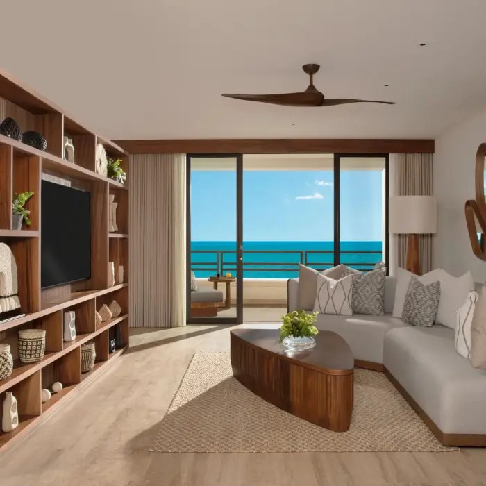Master Suite living room with ocean view, modern couch, wood decor, and entertainment center.