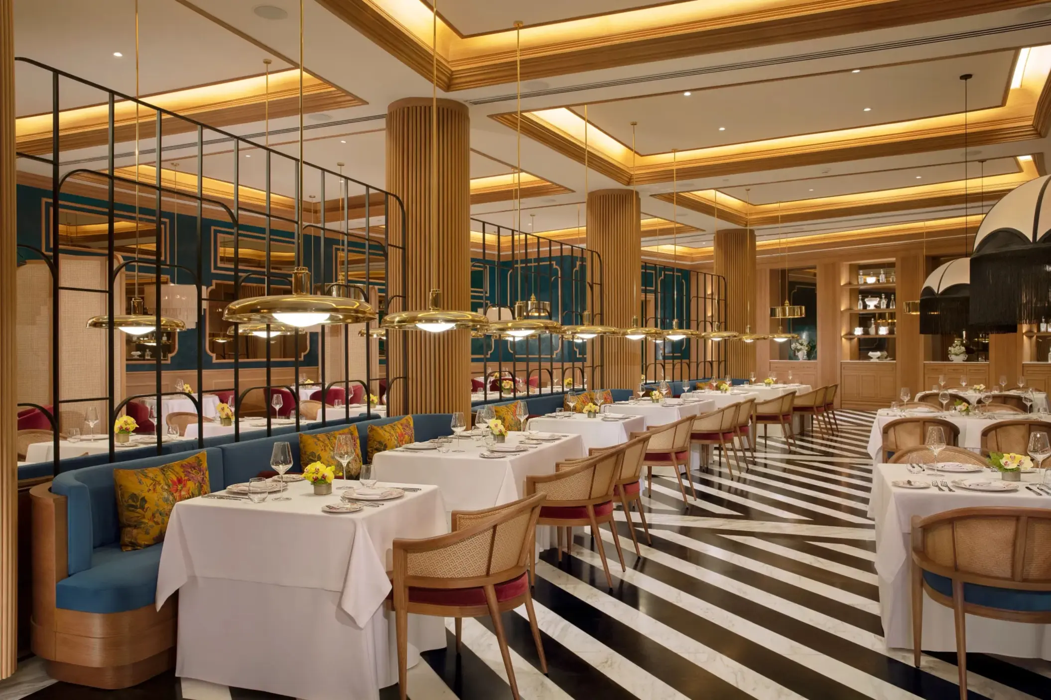 Elegant French restaurant Bordeaux featuring striped marble floors, gold lighting, and plush seating.