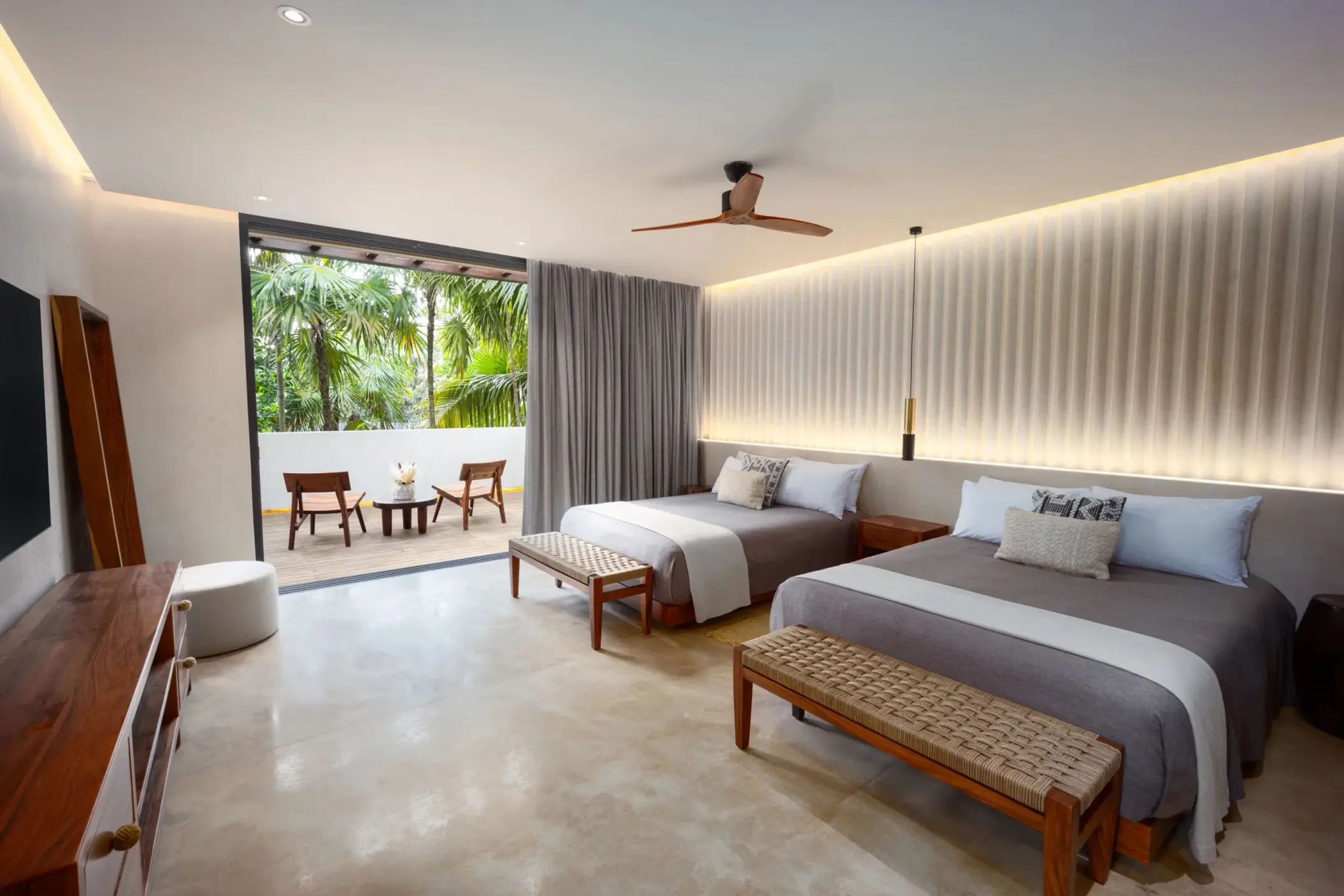 Double bedroom with crisp white linens, wooden furniture, and soft natural light.