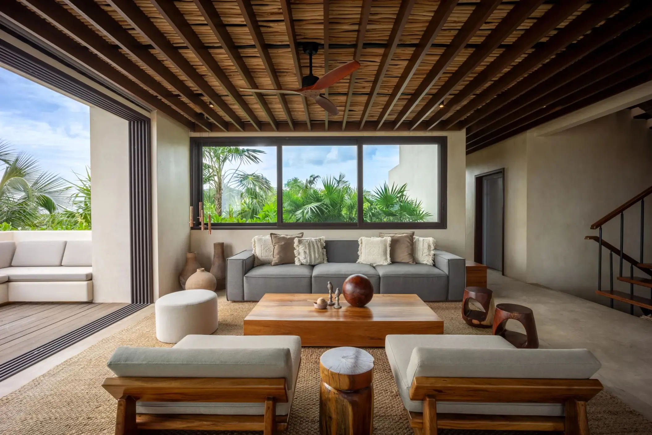 Indoor dining area with rustic wood table, open layout, and contemporary tropical accents.