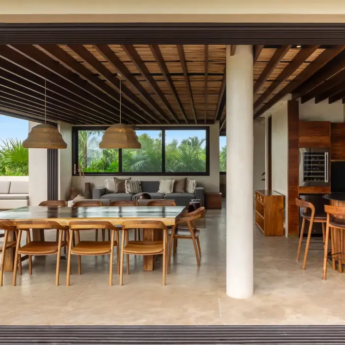 Spacious villa kitchen with natural wood cabinets, premium appliances, and tropical garden views.