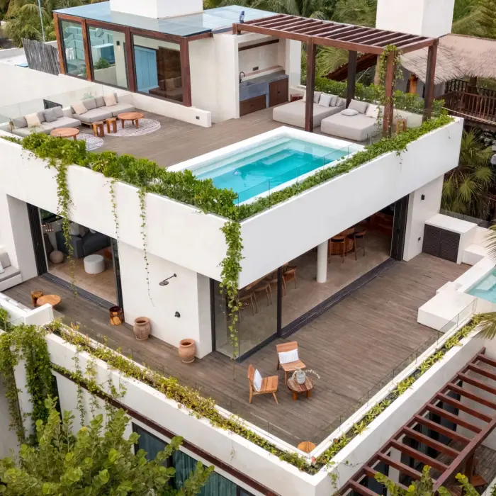 Private beachfront villa terrace with plunge pool, outdoor seating, and palm-framed ocean views.