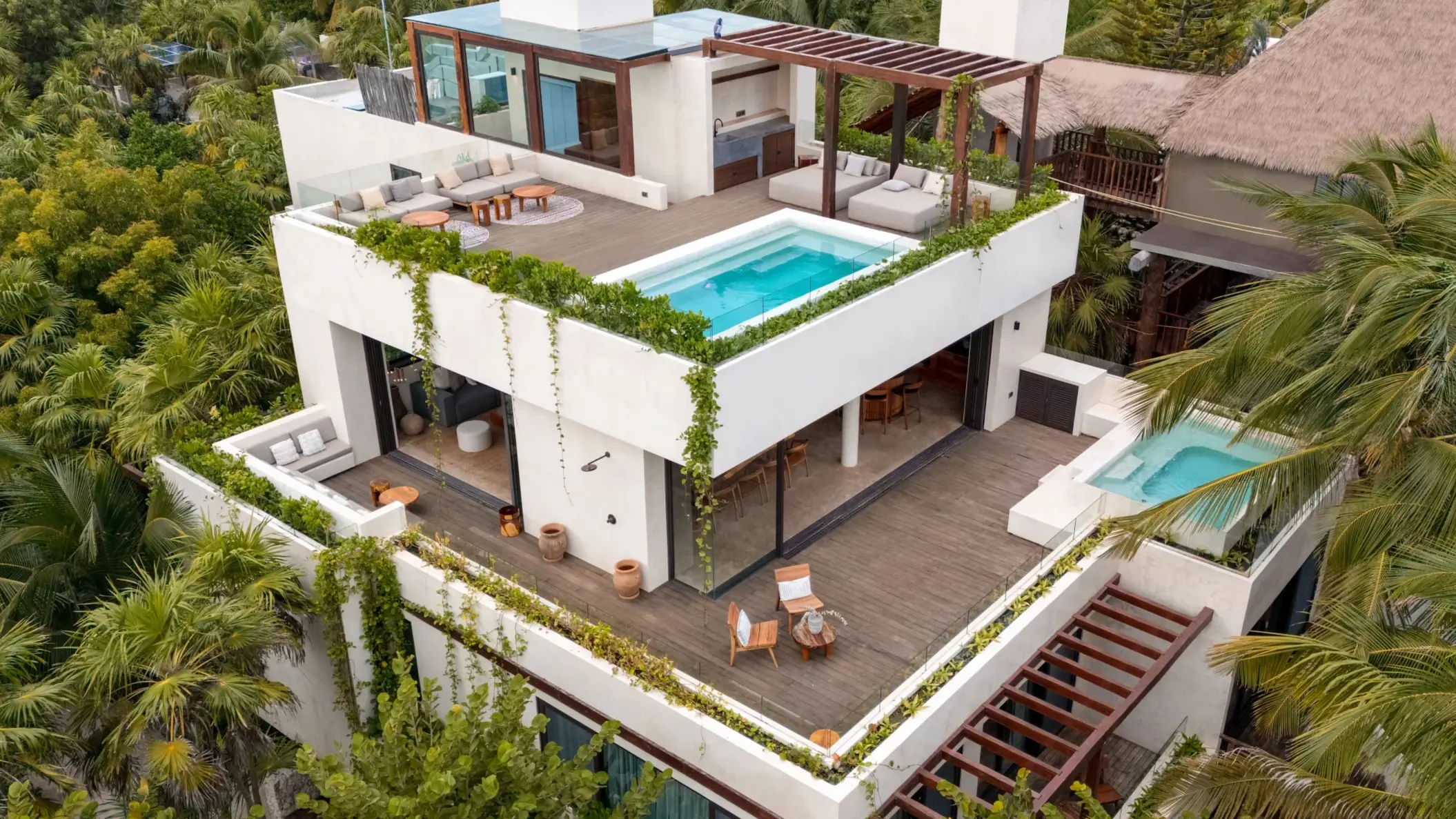 Private beachfront villa terrace with plunge pool, outdoor seating, and palm-framed ocean views.