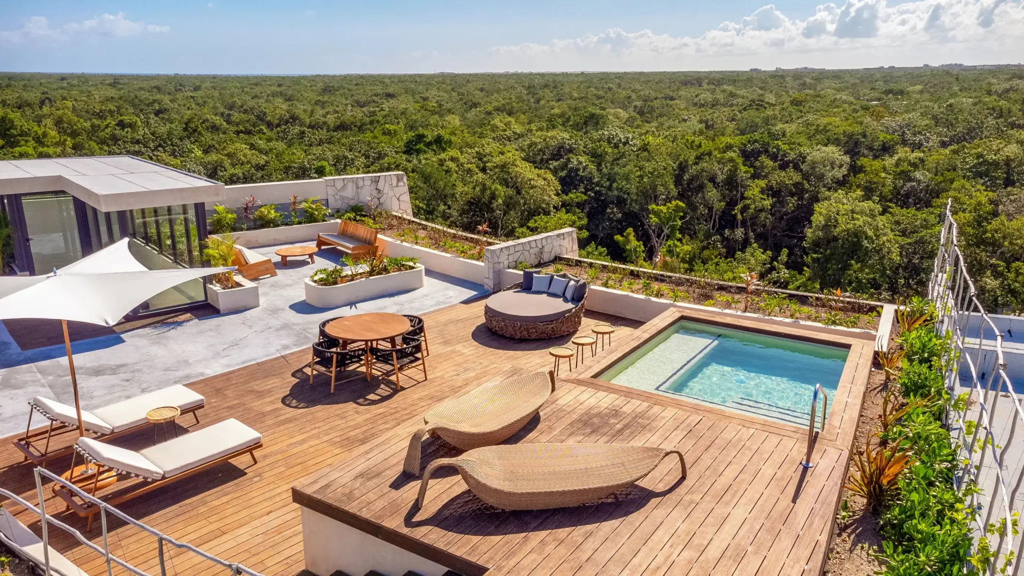 Expansive rooftop terrace with loungers, plunge pool, and stunning jungle and ocean views.