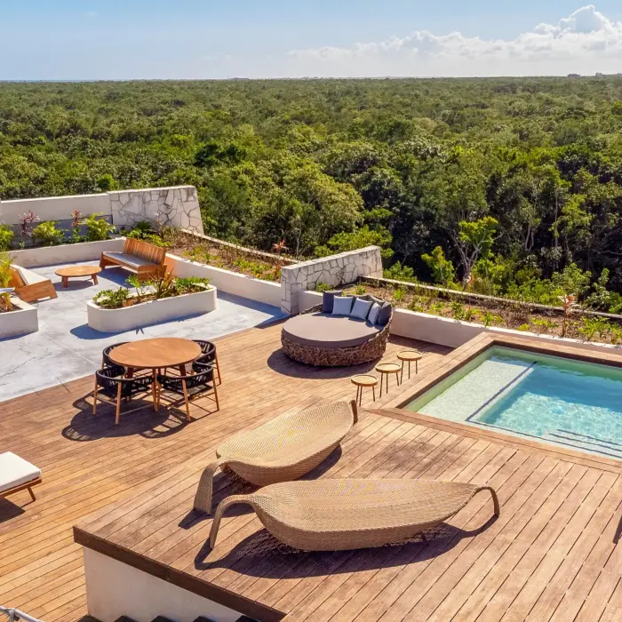 Expansive rooftop terrace with loungers, plunge pool, and stunning jungle and ocean views.
