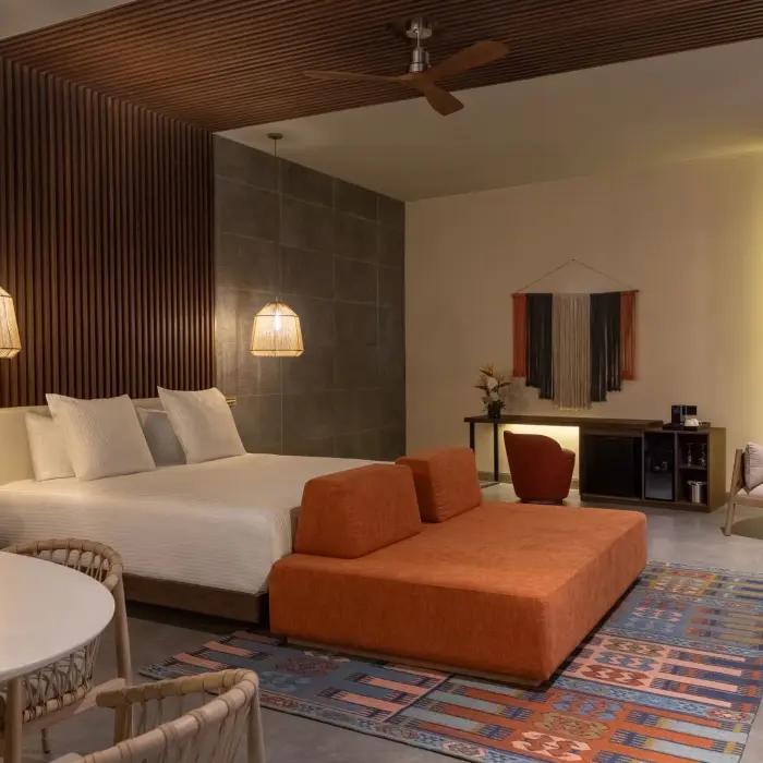 Elegant rooftop suite bedroom with minimalist design, canopy bed, and sliding doors to outdoor area.