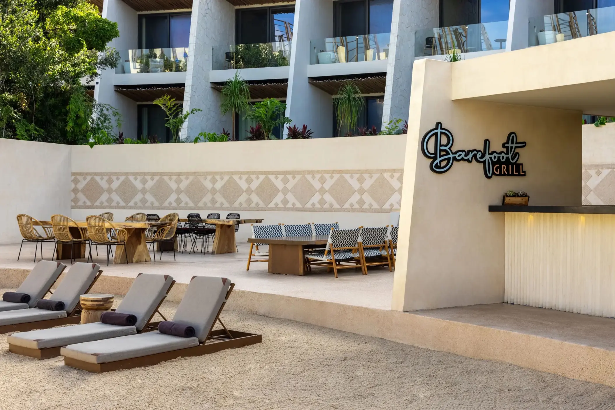 Open-air Barefoot Grill with wooden counters, shaded seating, and casual beachside atmosphere.