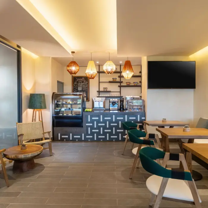 Cozy Coco Café with modern counters, warm lighting, and sweet pastries displayed behind glass.
