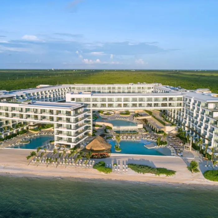Aerial view of Sensira Riviera Maya surrounded by lush jungle and beachfront pools.