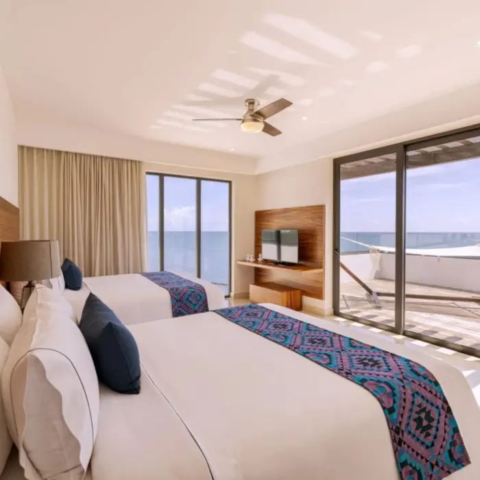 Double queen room with ocean views, flat screen TV, and private balcony with hammock.