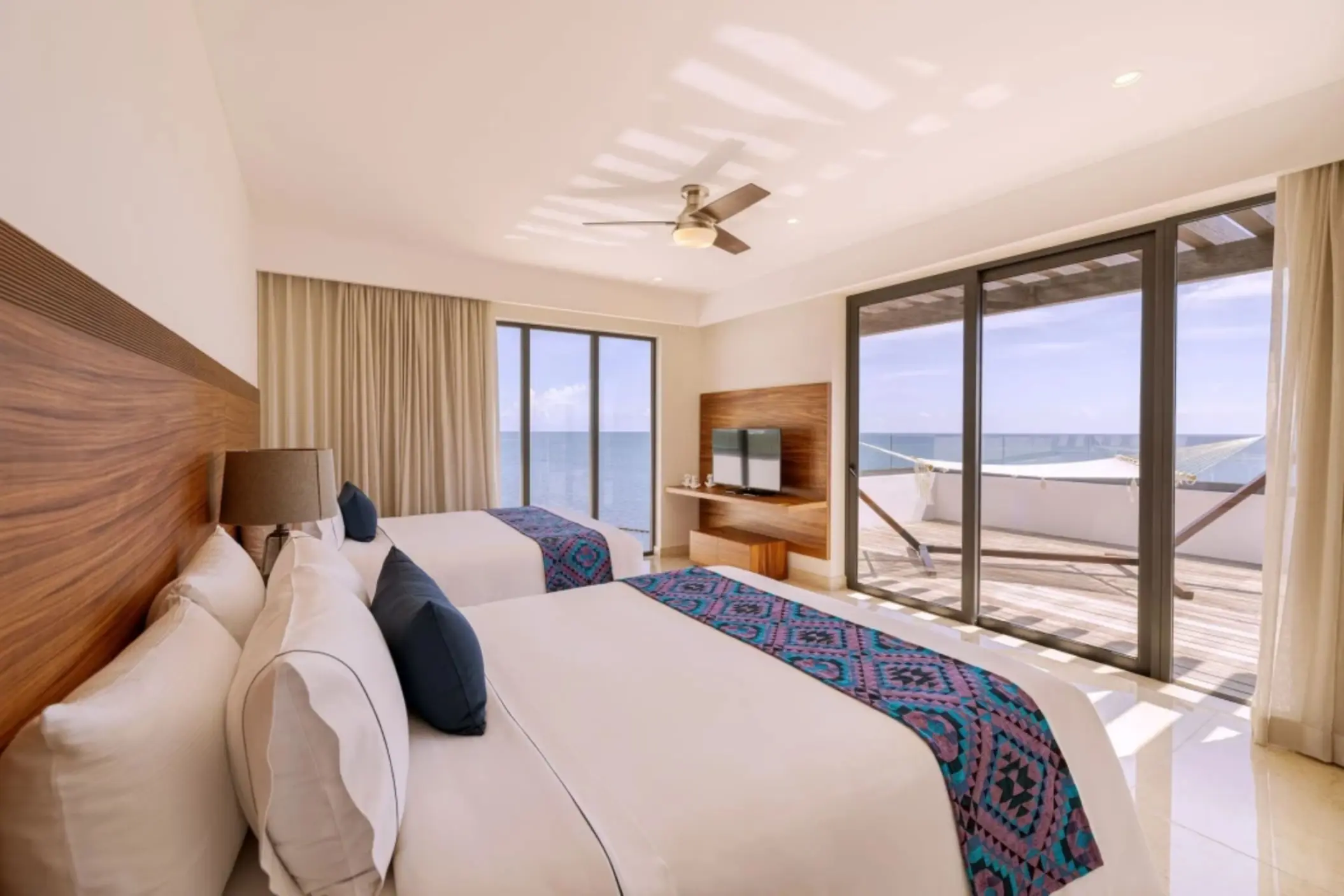 Double queen room with ocean views, flat screen TV, and private balcony with hammock.
