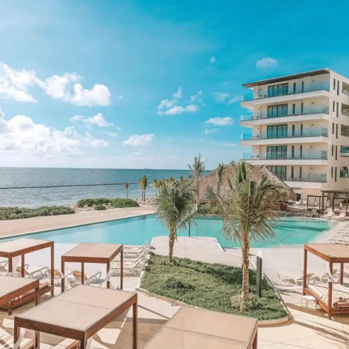 Infinity pool with ocean views, surrounded by cabanas and palm trees at Sensira Resort.