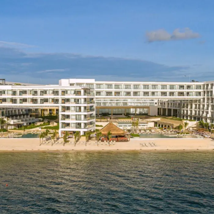 Wide beachfront resort view showing white building architecture and calm Caribbean waters.