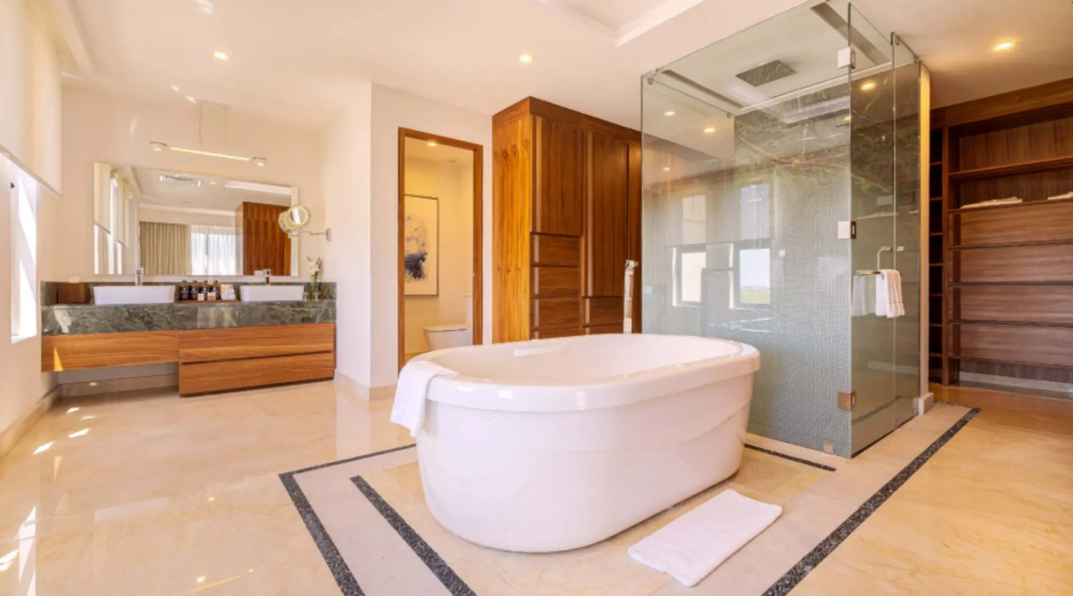 Spacious bathroom featuring a standalone soaking tub, large walk-in shower, and warm wood cabinetry throughout.