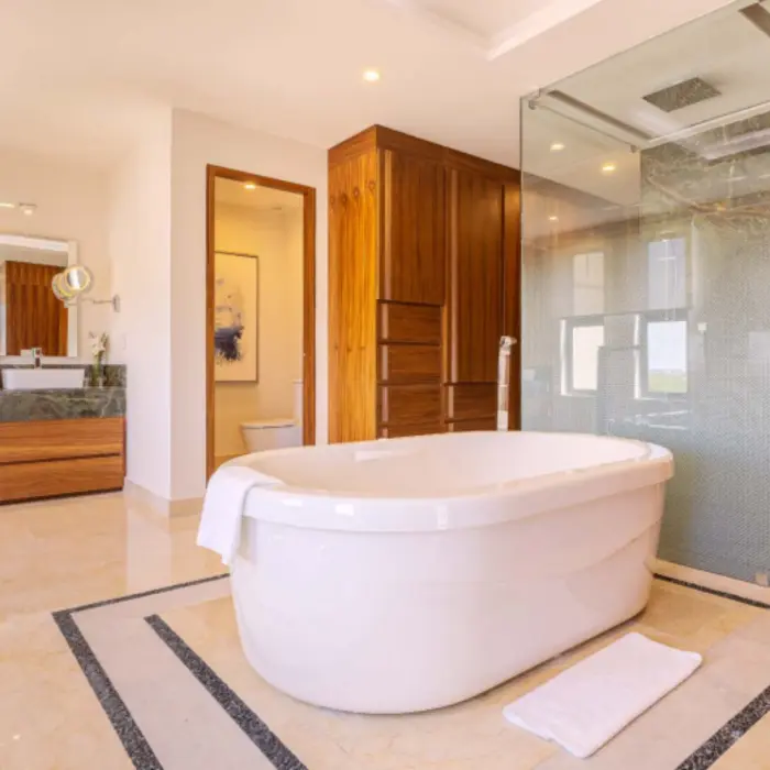 Spacious bathroom featuring a standalone soaking tub, large walk-in shower, and warm wood cabinetry throughout.