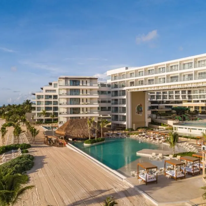 Aerial view of Sensira Riviera Maya showing beachfront, main pool, and palapa-roofed restaurant.
