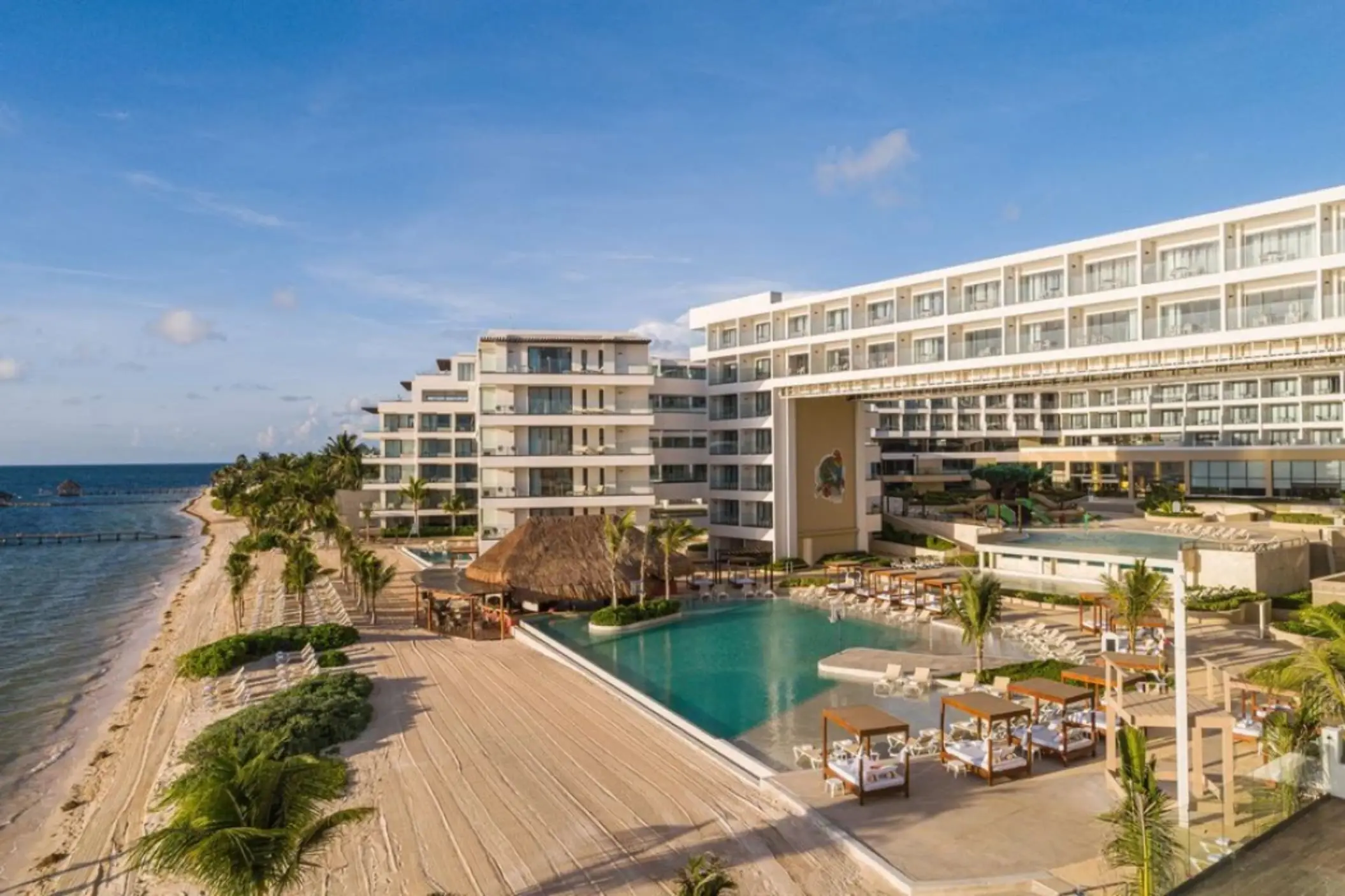 Aerial view of Sensira Riviera Maya showing beachfront, main pool, and palapa-roofed restaurant.