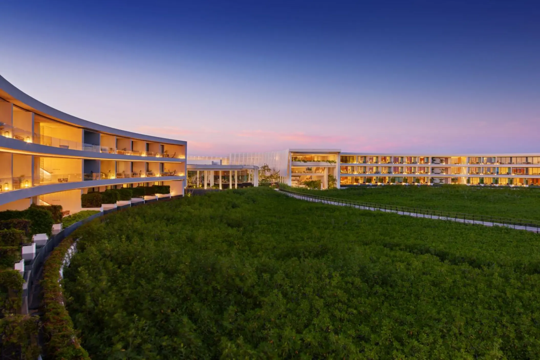 St. Regis Kanai Resort suite balconies with view of the forest in the evening