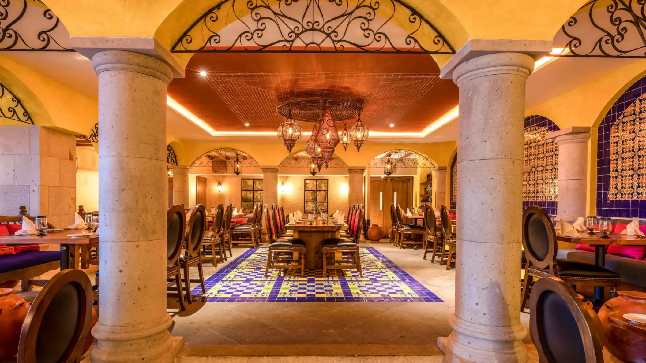 The interior of a Mexican restaurant, Casa De Rosa, featuring ornate columns and colorful tile flooring.