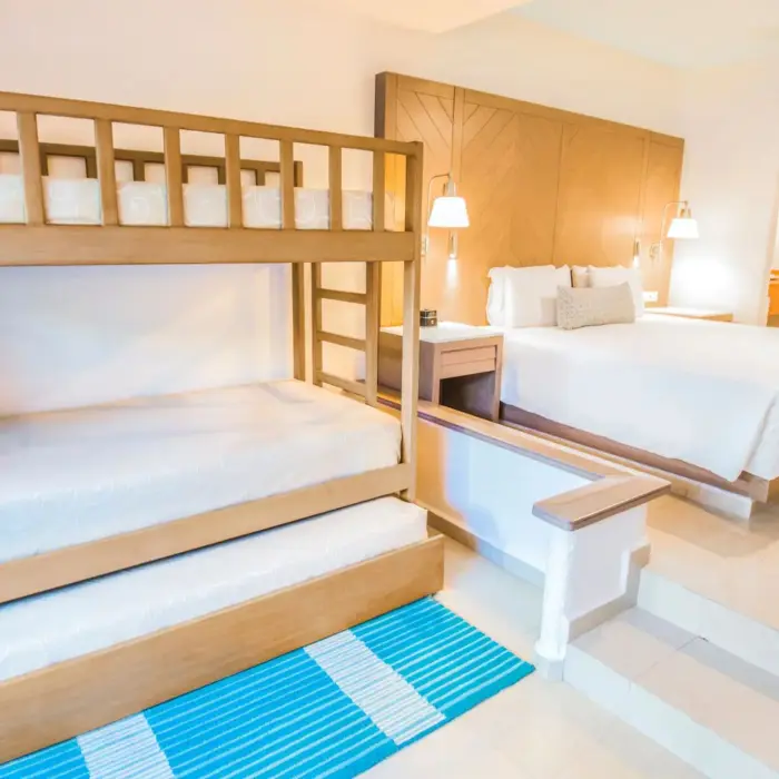 A family junior suite with a large bed and a wooden bunk bed, suitable for a family vacation.