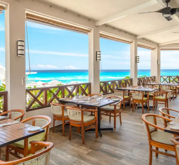 The Ventanas restaurant with outdoor seating and a stunning panoramic view of the beach and ocean.