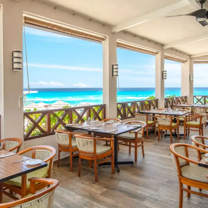 The Ventanas restaurant with outdoor seating and a stunning panoramic view of the beach and ocean.