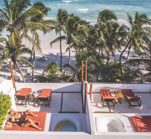 couple lounging on the terrace of their rooftop room at The Beach Tulum Hotel