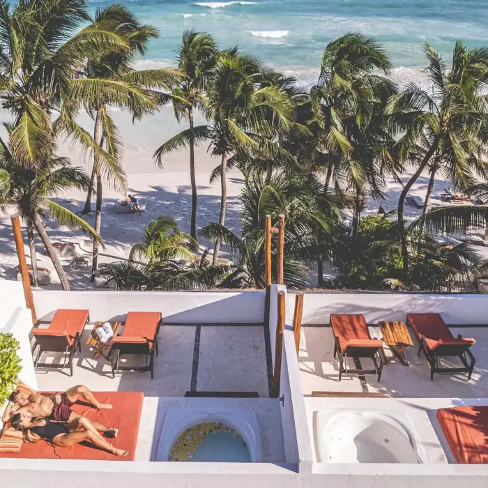 couple lounging on the terrace of their rooftop room at The Beach Tulum Hotel