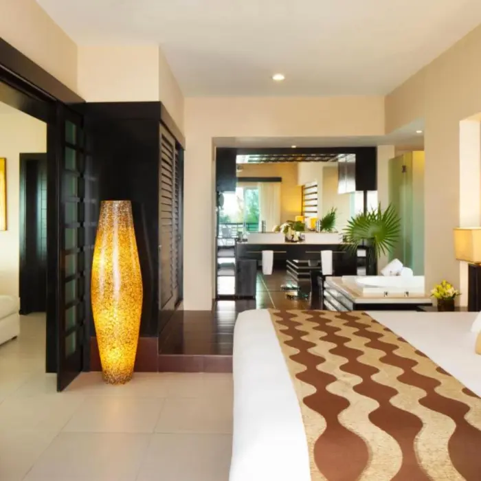 Interior of a spacious two-bedroom residence, showing a stylishly decorated bedroom with a large bed, modern furnishings, and a view into the living area.