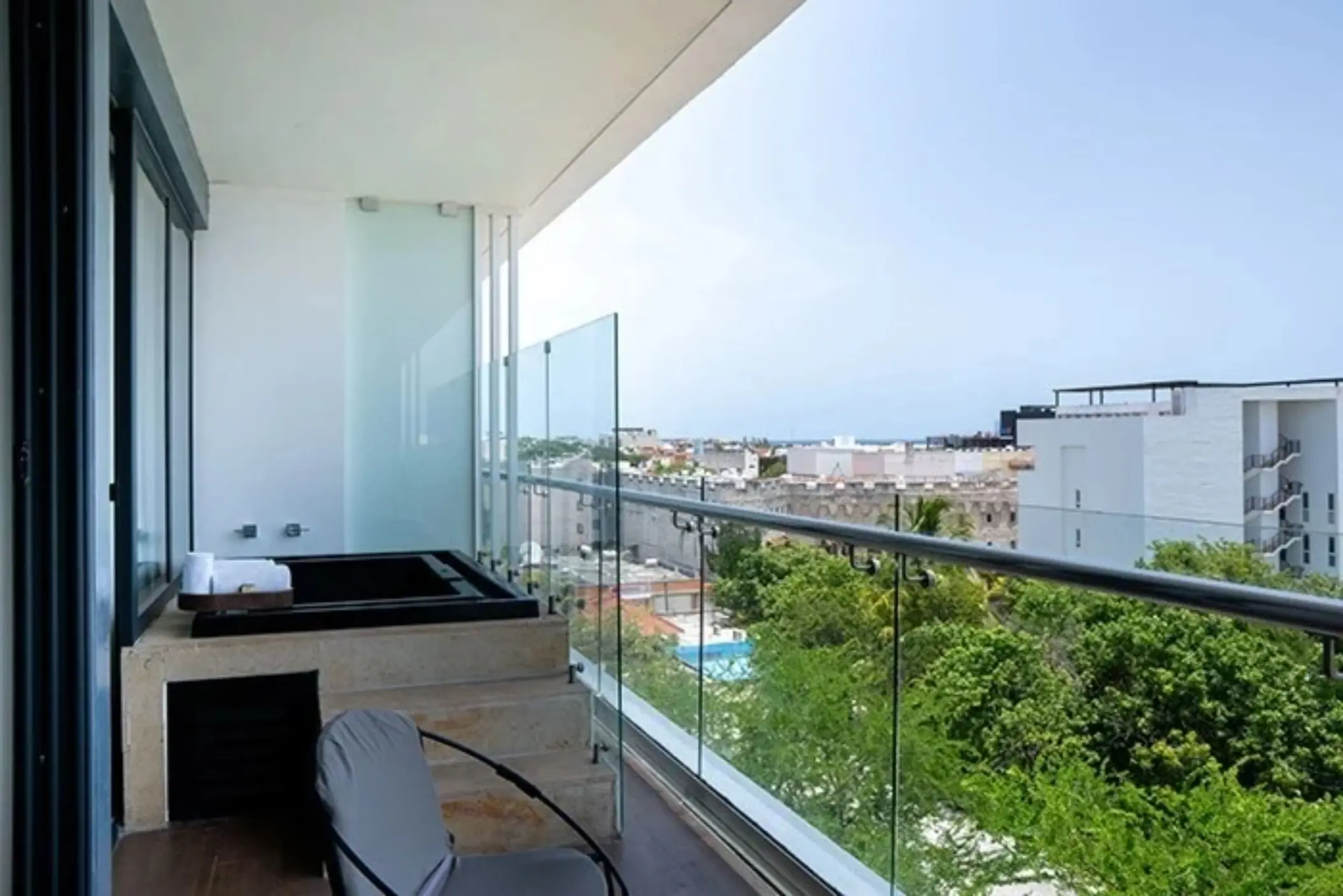 Private balcony with hot tub and glass railing overlooking Playa del Carmen from The Fives Downtown Hotel.