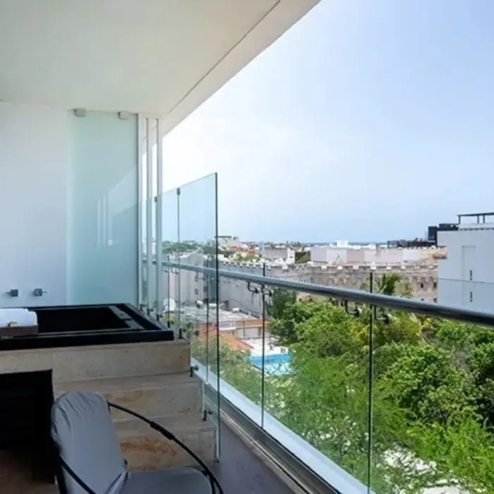 Private balcony with hot tub and glass railing overlooking Playa del Carmen from The Fives Downtown Hotel.
