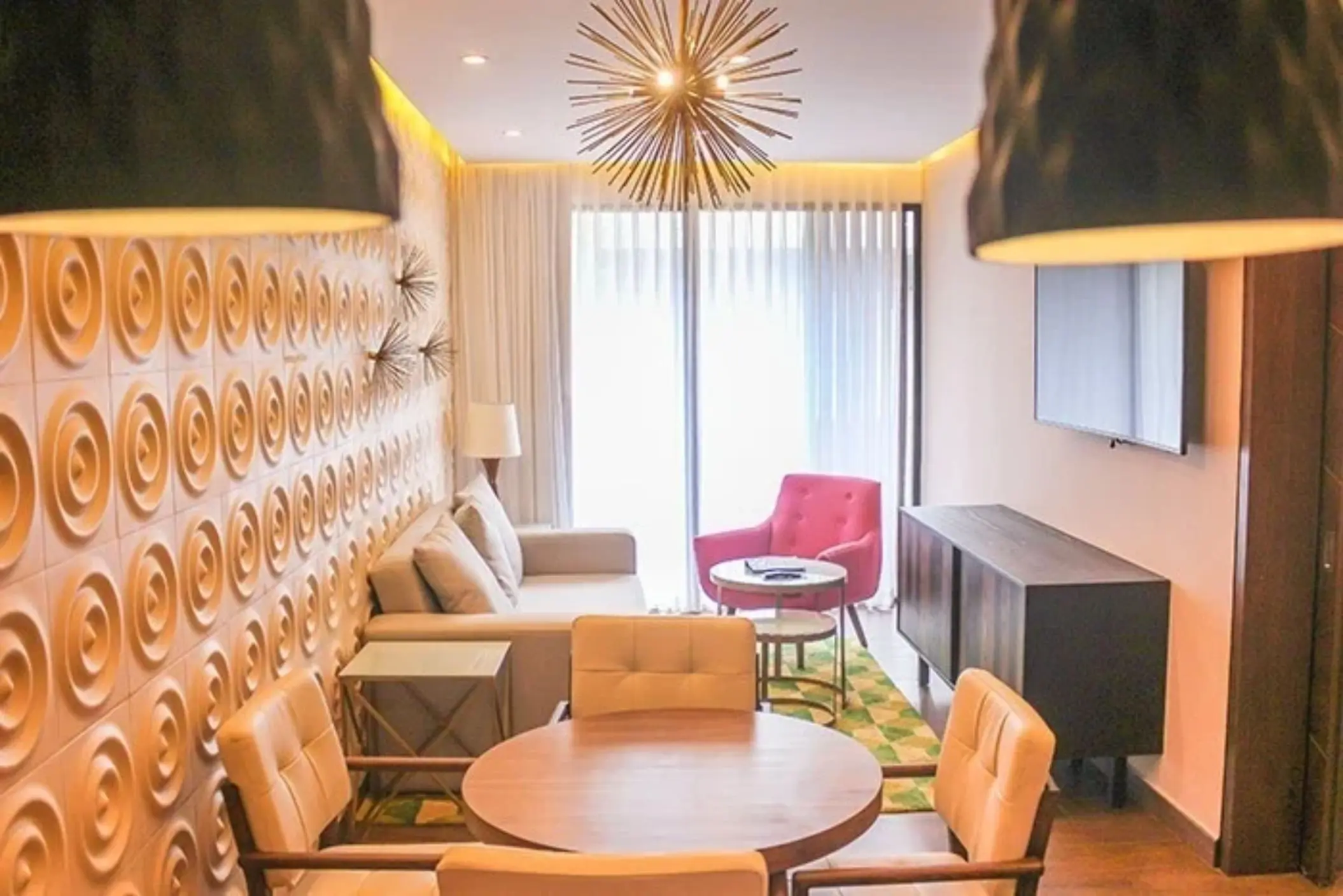 Compact lounge space with patterned feature wall, round table, and natural light at The Fives Downtown Hotel.