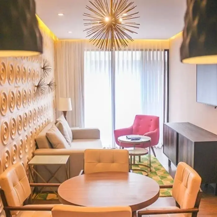 Compact lounge space with patterned feature wall, round table, and natural light at The Fives Downtown Hotel.
