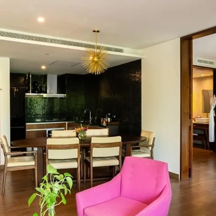 Modern dining area with round table, pink chair, and textured wall at The Fives Downtown Hotel.