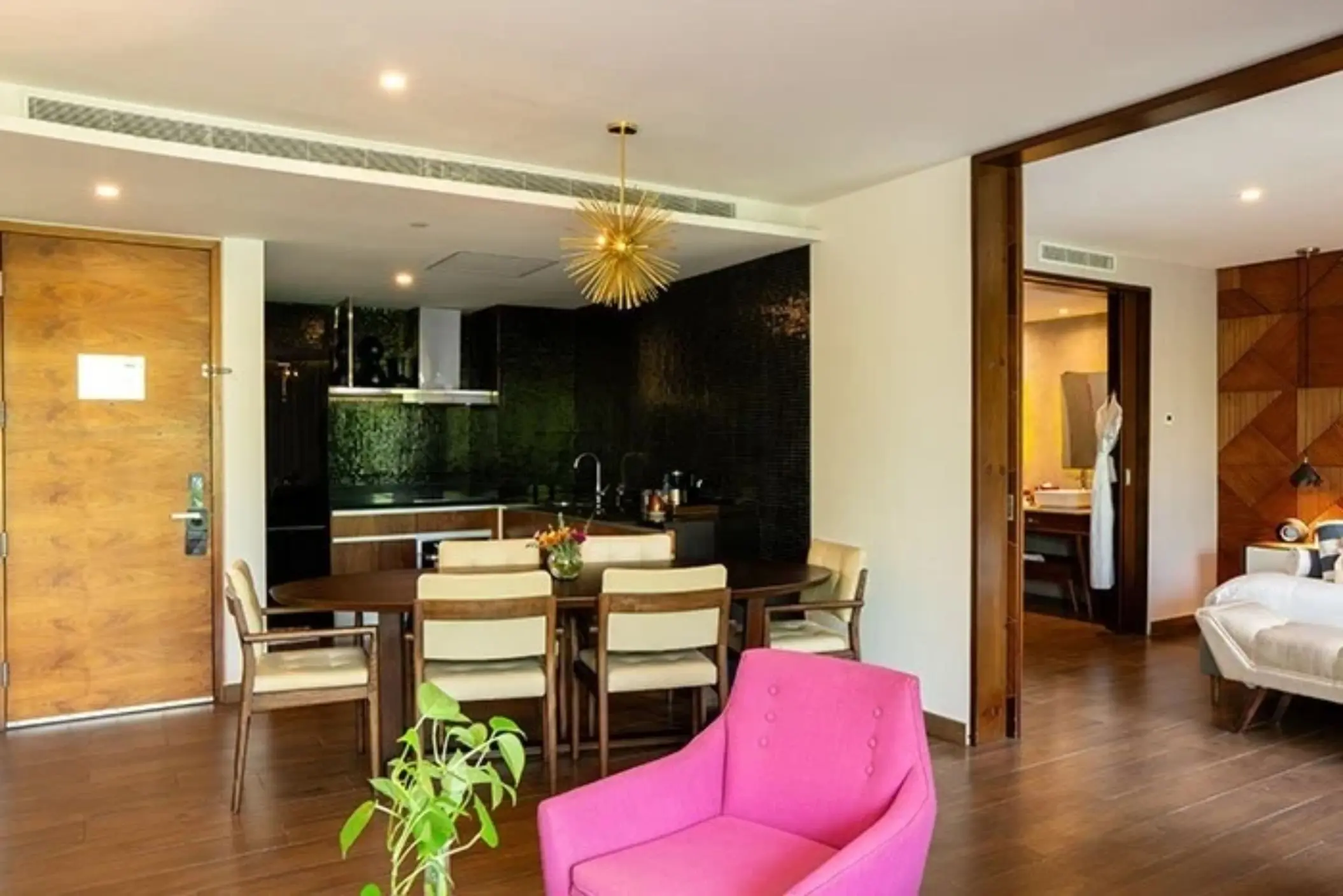 Modern dining area with round table, pink chair, and textured wall at The Fives Downtown Hotel.