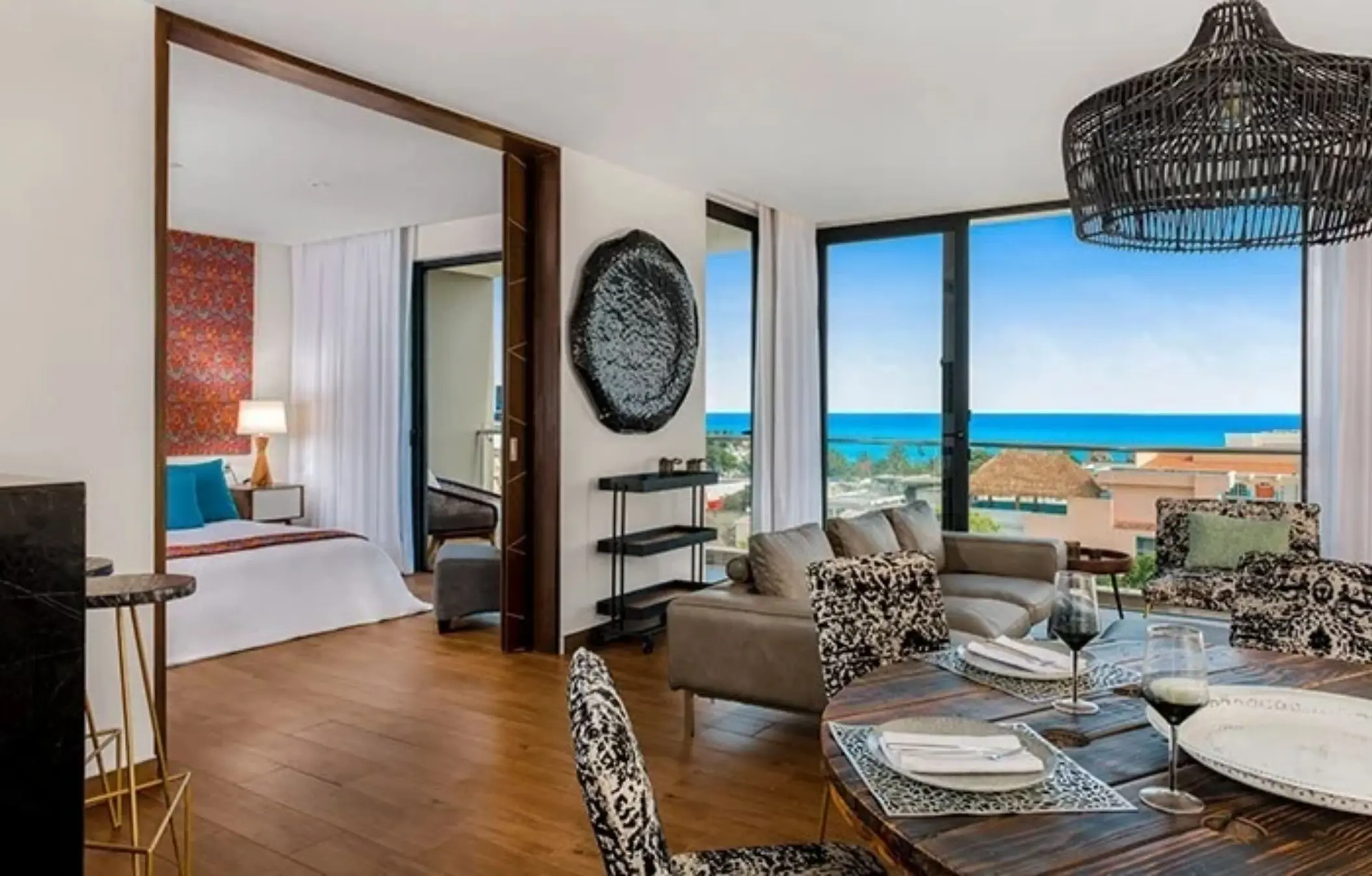 Luxury suite with ocean views, modern dining area, open-concept design, and separate bedroom with king bed.