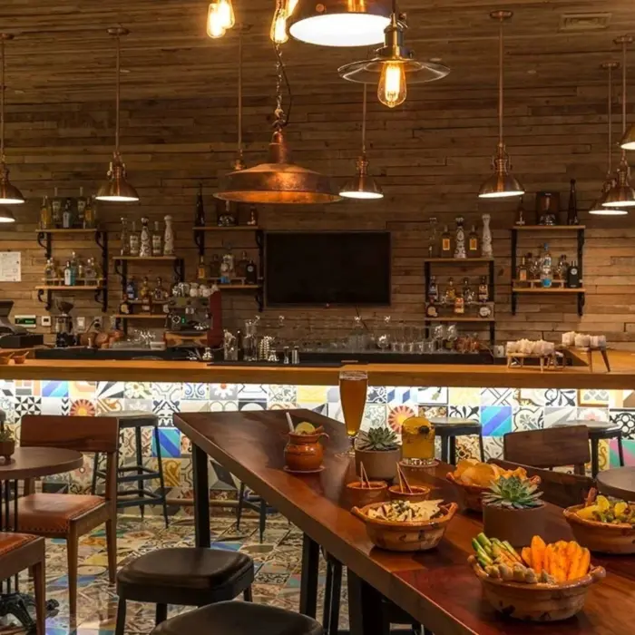 Rustic-themed indoor bar with wooden decor, vintage portraits, and artisanal cocktails.