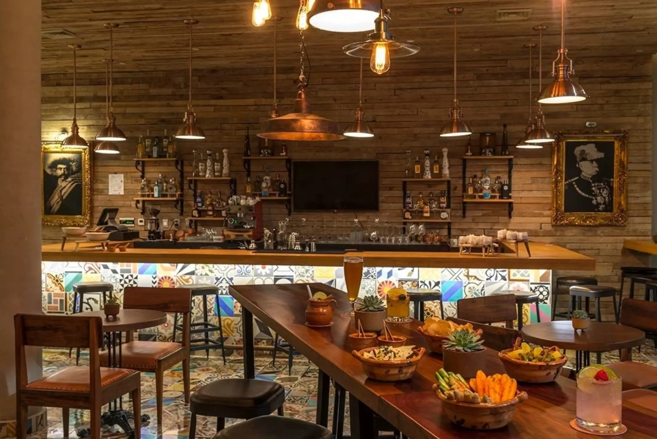 Rustic-themed indoor bar with wooden decor, vintage portraits, and artisanal cocktails.