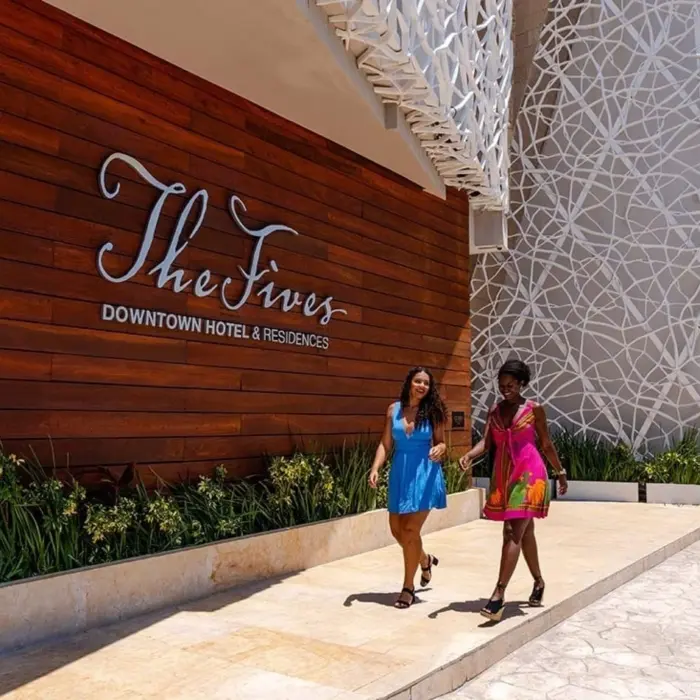Exterior view of The Fives Downtown Hotel & Residences with wood facade & logo signage.