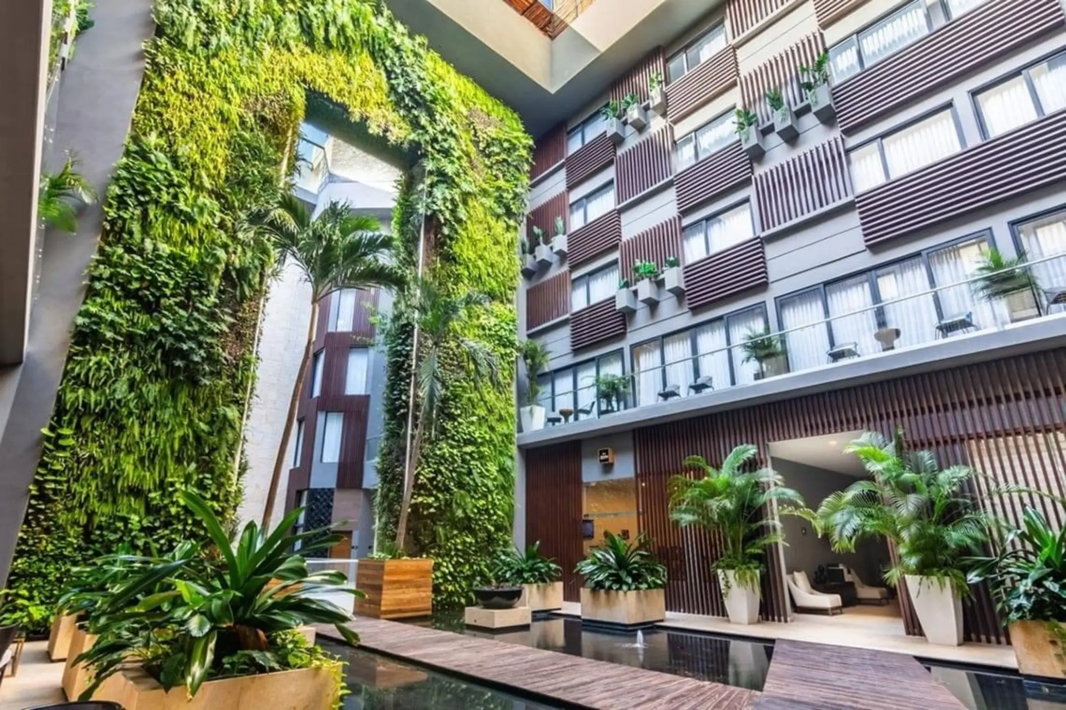 Vertical garden in an open-air courtyard with lush greenery and architectural lines at The Fives Downtown.