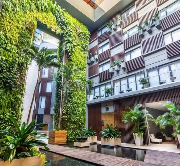 Vertical garden in an open-air courtyard with lush greenery and architectural lines at The Fives Downtown.
