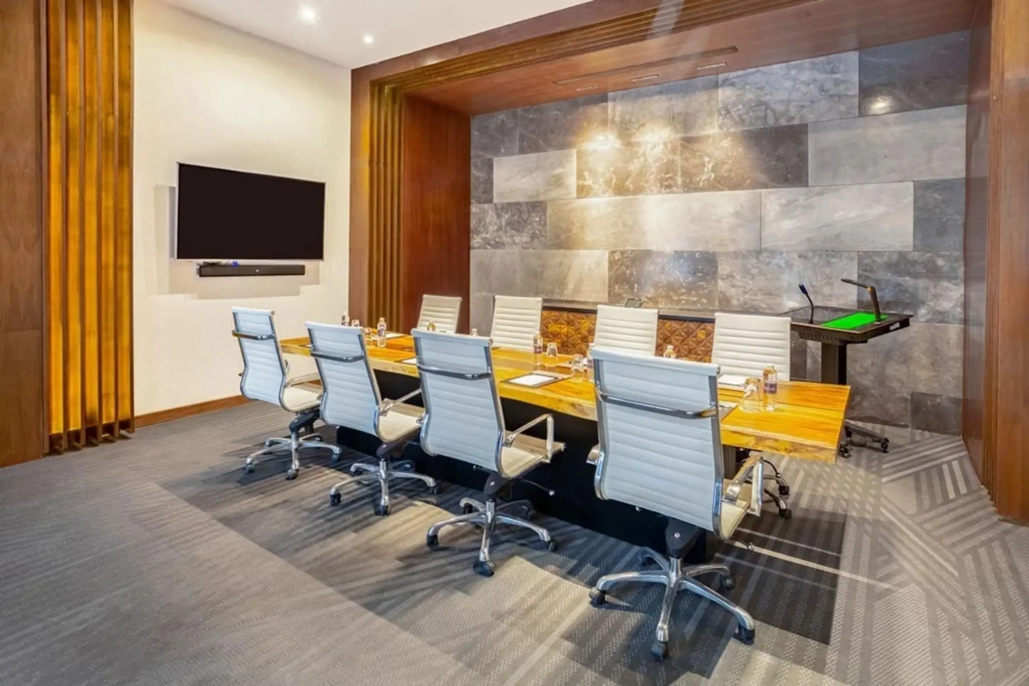 Sleek boardroom with modern design, leather chairs, and wood-accented meeting table.